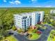 View of the building featuring coastal greenery, private parking and tropical foliage at 5300 S Atlantic Ave # 16-202, New Smyrna Beach, FL 32169