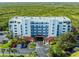 Aerial view of building featuring coastal scenery, private parking, a covered entrance and lush tropical foliage at 5300 S Atlantic Ave # 16-202, New Smyrna Beach, FL 32169