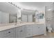 Bathroom featuring double sinks, white cabinetry, large mirror, and neutral-toned flooring at 5300 S Atlantic Ave # 16-202, New Smyrna Beach, FL 32169