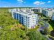 Low-angle aerial of a condominium complex featuring exterior balconies, parking, and landscaping at 5300 S Atlantic Ave # 16-202, New Smyrna Beach, FL 32169