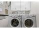 Convenient laundry area with a modern LG washer and dryer, plus overhead cabinet storage at 5300 S Atlantic Ave # 16-202, New Smyrna Beach, FL 32169