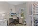 Bright office space with a light-colored desk, white chair, and natural light from the window at 5300 S Atlantic Ave # 16-202, New Smyrna Beach, FL 32169