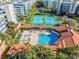 Aerial view of a pool and sunbathing area, surrounded by palm trees and lounge chairs at 5300 S Atlantic Ave # 16-202, New Smyrna Beach, FL 32169