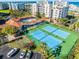 Aerial view of tennis courts, a pool, and rec building, with parking and landscaping around the condo complex at 5300 S Atlantic Ave # 16-202, New Smyrna Beach, FL 32169