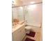 Bright bathroom features a glass-enclosed shower over tub, vanity with solid surface countertop and tile flooring at 5375 Compass Pt # 04, Oxford, FL 34484