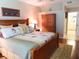 Comfortable bedroom with a wooden bed frame, neutral bedding, and access to the bathroom at 5375 Compass Pt # 04, Oxford, FL 34484