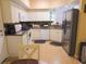 Well-lit kitchen featuring stainless steel appliances, ample cabinet space, and tile flooring at 5375 Compass Pt # 04, Oxford, FL 34484