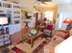 Open concept living room featuring a ceiling fan, built-in shelving, and wood flooring at 5375 Compass Pt # 04, Oxford, FL 34484