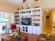 Comfortable living room with built-in shelving, a ceiling fan, and a view of the lanai at 5375 Compass Pt # 04, Oxford, FL 34484