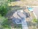 Wide aerial perspective of the home, highlighting its location, layout, and proximity to surrounding greenery and amenities at 548 E Belt Ave, Bushnell, FL 33513