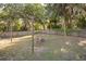 Large backyard featuring a rustic brick fire pit, wooden fence, mature trees, and lush green grass at 548 E Belt Ave, Bushnell, FL 33513
