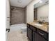 Bathroom features a shower with wood-look tile surround and dark cabinets with granite countertops at 548 E Belt Ave, Bushnell, FL 33513