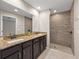 Bathroom features a double sink vanity, granite countertops, and a tiled walk-in shower at 548 E Belt Ave, Bushnell, FL 33513