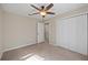 Cozy bedroom featuring neutral carpet, neutral walls, a ceiling fan, and a double door closet at 548 E Belt Ave, Bushnell, FL 33513