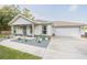 Charming single-Gathering home featuring a blue front door, an attached garage, and nicely landscaped front yard at 548 E Belt Ave, Bushnell, FL 33513