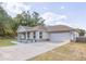 Charming single-Gathering home featuring a blue front door, an attached garage, and nicely landscaped front yard at 548 E Belt Ave, Bushnell, FL 33513