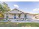 Charming single-Gathering home featuring a blue front door, an attached garage, and nicely landscaped front yard at 548 E Belt Ave, Bushnell, FL 33513
