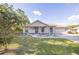 Charming single-Gathering home featuring a blue front door, an attached garage, and nicely landscaped front yard at 548 E Belt Ave, Bushnell, FL 33513