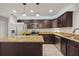 This kitchen features stainless appliances, granite countertops, an island, and dark cabinets at 548 E Belt Ave, Bushnell, FL 33513