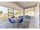 Covered and screened patio featuring an outdoor seating area and views of the fenced backyard at 548 E Belt Ave, Bushnell, FL 33513