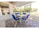 Relaxing screened porch featuring stylish chairs, a table with a vibrant tablecloth, and a welcoming atmosphere at 548 E Belt Ave, Bushnell, FL 33513
