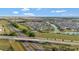 Expansive aerial view of a well-planned community with a lake, surrounded by lush greenery and convenient highway access at 5702 Grimes Ct, The Villages, FL 32163