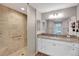 Bathroom featuring granite countertops, a glass enclosed shower, and white cabinets at 5702 Grimes Ct, The Villages, FL 32163