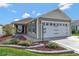 A charming home showcases a two-car garage, inviting front patio, and a meticulously maintained front yard at 5702 Grimes Ct, The Villages, FL 32163