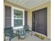 Inviting front porch showcasing two chairs, a table, and a 
