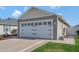 The exterior displays a well-maintained home with a two-car garage and carefully manicured green grass at 5702 Grimes Ct, The Villages, FL 32163