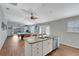 Open-concept kitchen with an island, stainless steel dishwasher, and a view into the game room at 5702 Grimes Ct, The Villages, FL 32163