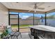 Enclosed patio featuring a hot tub and seating, perfect for relaxing and entertaining outdoors at 5702 Grimes Ct, The Villages, FL 32163
