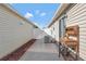 The side yard features a concrete walkway with decorative rocks and exterior home fixtures at 5702 Grimes Ct, The Villages, FL 32163
