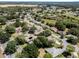An aerial image displays houses surrounded by verdant foliage, offering a sense of community within a serene environment at 5906 Prince Philip Ct, Leesburg, FL 34748