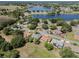 A beautiful aerial view showcases houses interspersed with lush greenery and a serene lake, highlighting a peaceful neighborhood at 5906 Prince Philip Ct, Leesburg, FL 34748