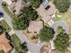 This aerial shot features a house with a well-maintained lawn, surrounded by lush trees and located on a quiet street at 5906 Prince Philip Ct, Leesburg, FL 34748