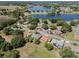 An aerial photo reveals a cluster of homes surrounded by mature trees and a tranquil lake, creating a serene community setting at 5906 Prince Philip Ct, Leesburg, FL 34748