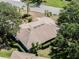 Aerial showcase of a neatly roofed home amidst lush landscaping and mature trees, enhancing its curb appeal and charm at 5906 Prince Philip Ct, Leesburg, FL 34748