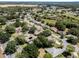 This aerial view presents homes with swimming pools surrounded by lush greenery and a lake, illustrating community and tranquility at 5906 Prince Philip Ct, Leesburg, FL 34748