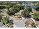 Aerial view of home in a neighborhood near a lake with mature trees at 5906 Prince Philip Ct, Leesburg, FL 34748