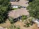 Aerial view of a well-landscaped home with mature trees and a paved driveway at 5906 Prince Philip Ct, Leesburg, FL 34748