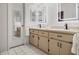 Bright bathroom features double sinks, lighted mirrors, and stylish vanity with black hardware at 5906 Prince Philip Ct, Leesburg, FL 34748
