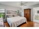 Relaxing bedroom boasts a large window, modern ceiling fan, and sleek, hardwood flooring throughout at 5906 Prince Philip Ct, Leesburg, FL 34748