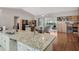 Open-concept living room with hardwood floors, a ceiling fan, and sliding glass doors to the lanai at 5906 Prince Philip Ct, Leesburg, FL 34748