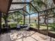 Screened patio with tile flooring, seating, and a view of the lush backyard at 5906 Prince Philip Ct, Leesburg, FL 34748