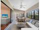 Well-lit sunroom with tile flooring, ceiling fan, dining table, sitting area, and large windows at 5906 Prince Philip Ct, Leesburg, FL 34748