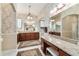 Spacious bathroom with dual sinks, make-up vanity, granite countertops, decorative wallpaper, and a walk-in shower at 630 Laurel Run, The Villages, FL 32162