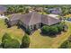 Exterior of the home with mature landscaping, lush green lawn, and well-maintained grounds at 630 Laurel Run, The Villages, FL 32162