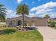 Inviting home with a well-manicured lawn, charming landscaping, and a convenient two-car garage at 630 Laurel Run, The Villages, FL 32162