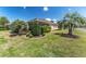 Exterior view of the home with a well-manicured lawn and tropical landscaping at 630 Laurel Run, The Villages, FL 32162